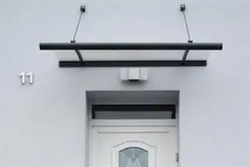 Eine weiße Tür mit einem Baldachin darüber und der Nummer 11 an der Wand.